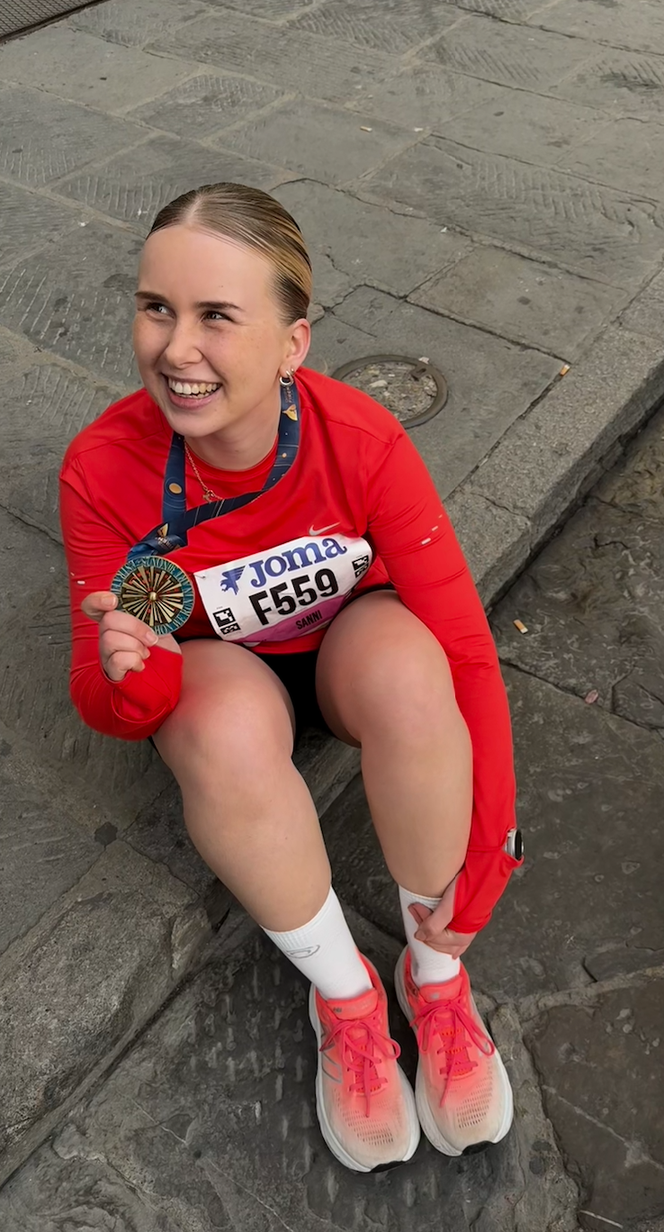 Sanni at a marathon with her medal and race bib