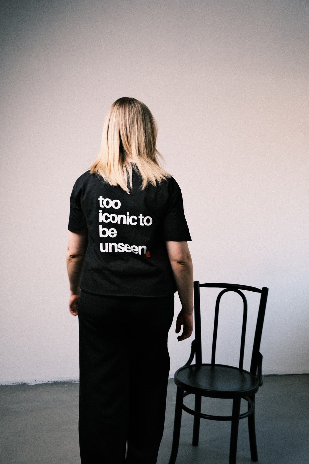 Person wearing a t-shirt reading too iconic to be unseen